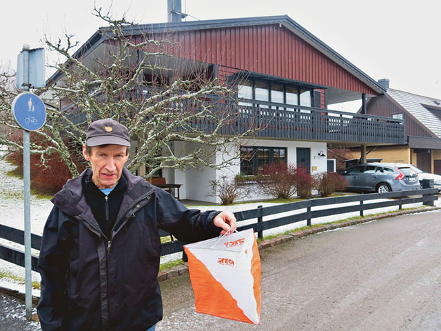Håkan Gustafsson med en orienteringsskärm i handen och framför hans och Carinas villa på Björkstigen i Boxholm.