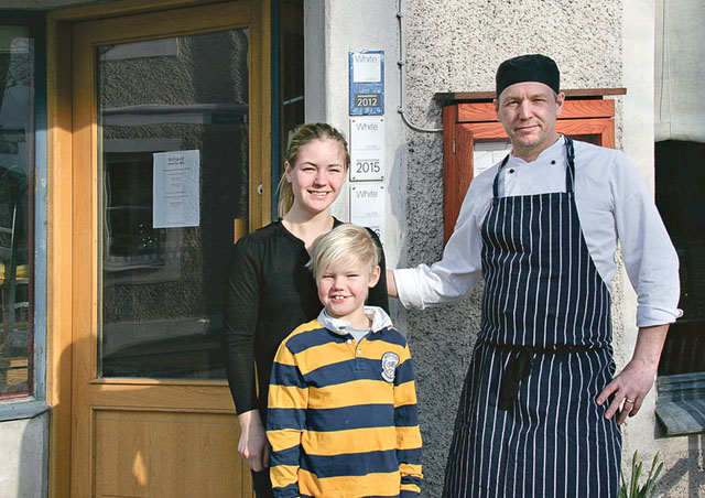 Malin Unéus, sonen Julius Unéus och sambon Fredrik Gustafsson utanför sin restaurang.