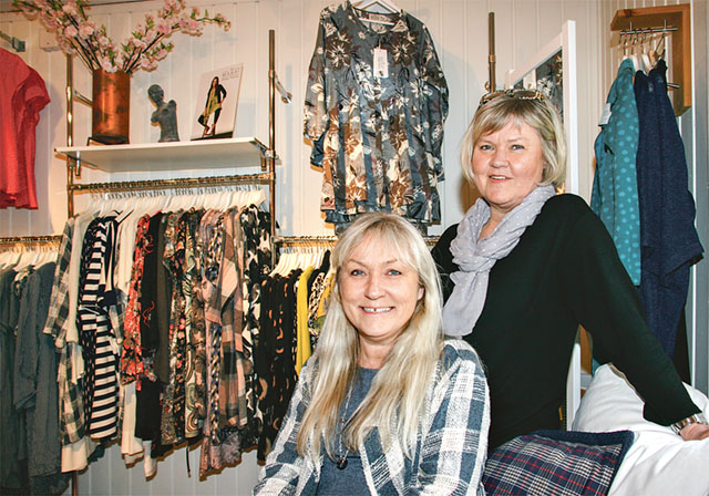 Eva Granlund och Helena Andersson bland butikens kläder.
