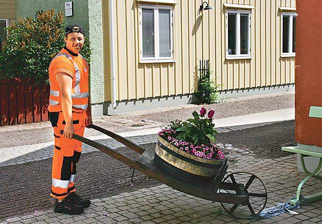 Gustav Johansson, kommunal feriepraktikant i Vadstena, ställer en blomsterkärra rätt.