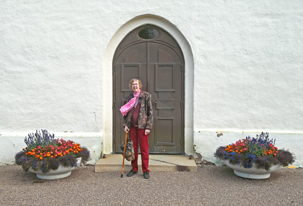 Maj-Britt vid kyrkporten i Vinnerstad. Här har familjen gått in många gånger
