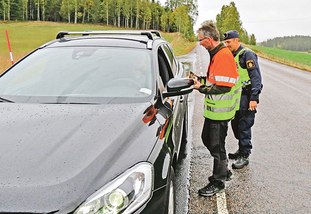 Per Gustavsson ger information och delar ut markeringsremsor till en bilist, sedan Karl Landström, kollat körkort och utfört nykterhetskontroll.